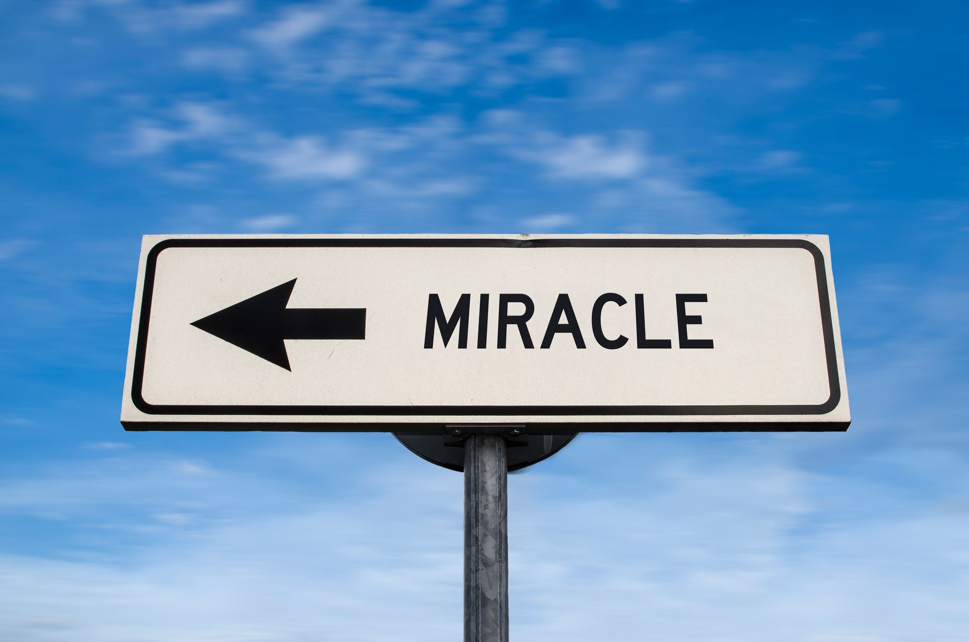 Miracle road sign, arrow on blue sky background. One way blank road sign with copy space. Arrow on a pole pointing in one direction.