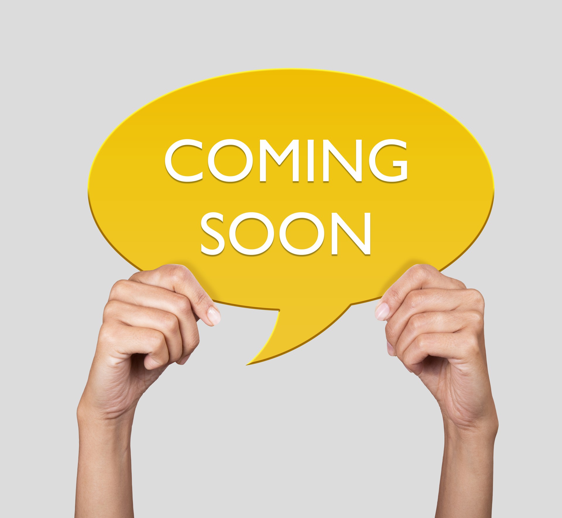 Hand showing coming soon on speech bubble